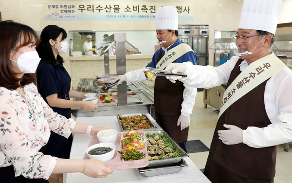 윤재갑 의원(사진 오른쪽에서 첫번째)과 임준택 회장(사진 우측에서 두번째)이 임직원들에게 우리 수산물 소비 촉진을 위해 수산물 요리를 직접 배식하고 있다.