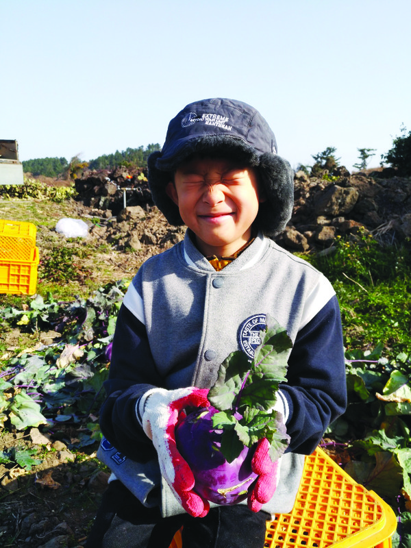 아이들도 가끔 농원에서 일손을 도우며 체험 활동을 한다. 사진은 둘째 아들 김현승 군이 수확한 콜라비를 들고 웃고 있는 모습.