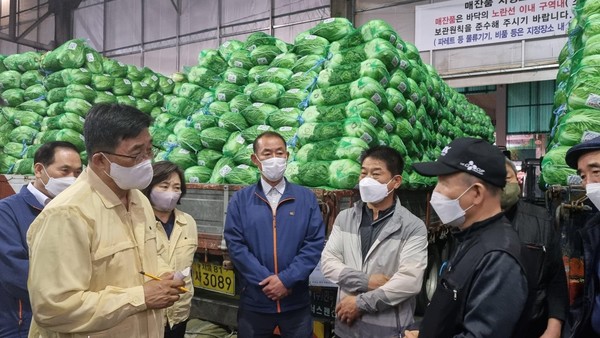 김춘진 한국농수산식품유통공사(aT) 사장이 가락동농수산물도매시장 유통인들을 만나 배추 시장을 점검하고 정부 비축배추의 품질과 규격에 대해 듣고 있다.