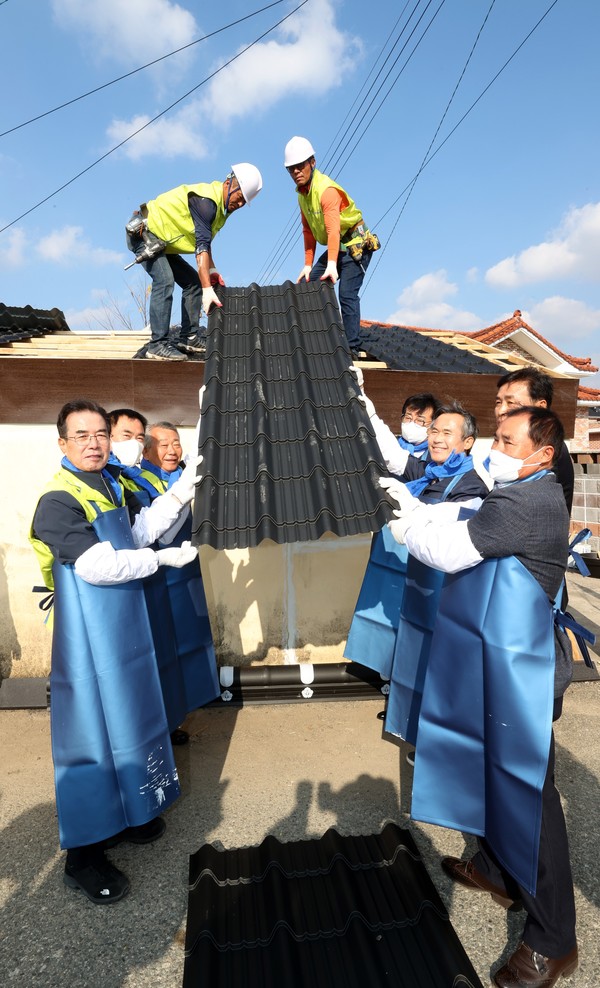 이성희 농협중앙회장(왼쪽 첫 번째)과 김승남 의원(오른쪽에서 세 번째) 등 참석자들이 지붕 수리 작업을 하고 있다.