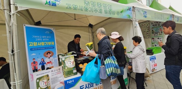 서울농협 부스를 방문한 시민들을 대상으로 고향사랑기부제 홍보 리플릿과 사은품을 배부하고 있다.