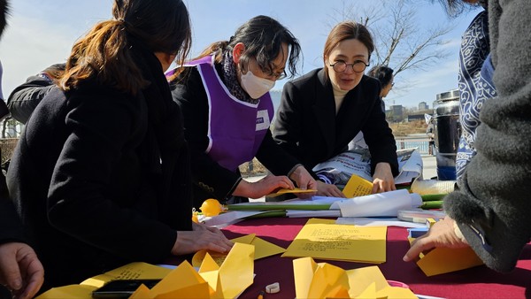 ‘평화의 길로 나아가는 대한민국을 바라는 염원‘을 담은 종이비행기를 접고 있는 행사주관 단체들과 김현미 세종시의원