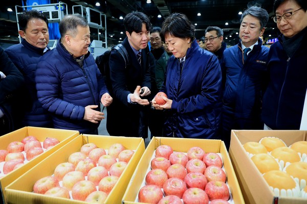 송미령 농식품부 장관(가운데)이 가락시장 과일 경매장에서 시장 관계자들과 사과 수급상황에 대해 의견을 나누고 있다.  