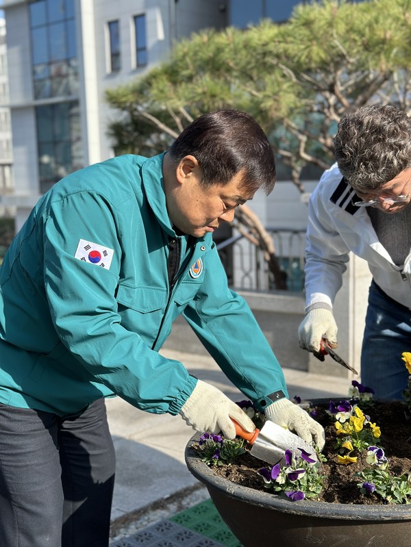 이병도 천안교육장이 15일 청사 앞 대형 화분에 꽃을 식재하고 있다.