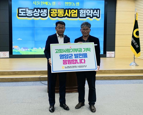 지난 4일 김상수 농협서울본부장은 도농상생 공동사업 협약을 축하하며 영암군 발전을 위한 고향사랑기부금을 기탁했다.(왼쪽부터 김상수 농협서울본부장, 김광호 영암군청 군정홍보과장)