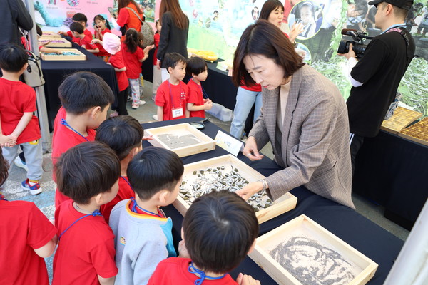 누에체험존에서 누에를 보면서 설명듣는 어린이들.