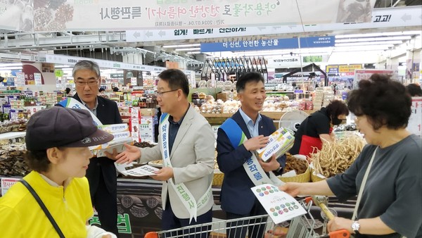 전영득 농협 약용작물전국협의회장 등 참석자들이 기념품과 홍보 유인물을 전달하며 약용작물을 홍보하고 있다.