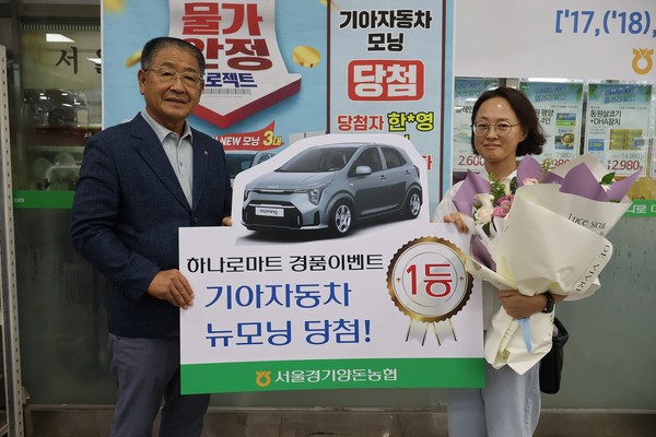 이정배 조합장(사진 왼쪽)이 하나로마트 김포점에서 1등에 당첨된 고객에게 경품을 전달한 후 기념촬영을 하고 있다.