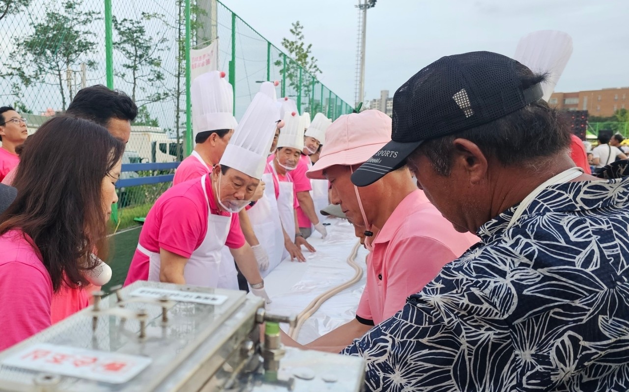 116년 복숭아재배 의미를 담은 116미터 복숭아 가래떡 뽑기를 진행하고 있는 모습.  (사진=박나라 기자)