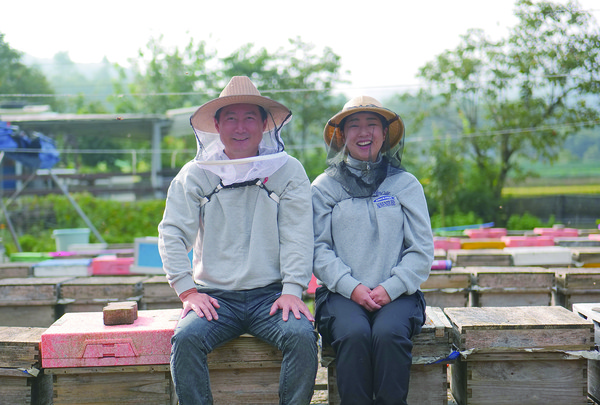 최고야 해밀당 대표는 체험 프로그램을 통한 지역 활성화를 위해 채밀 체험, 쿠킹 클래스, 밀랍초 만들기 등을 운영하고 있다. 사진은 최 대표와 그의 남편이 양봉장에서 환히 웃고 있는 모습.