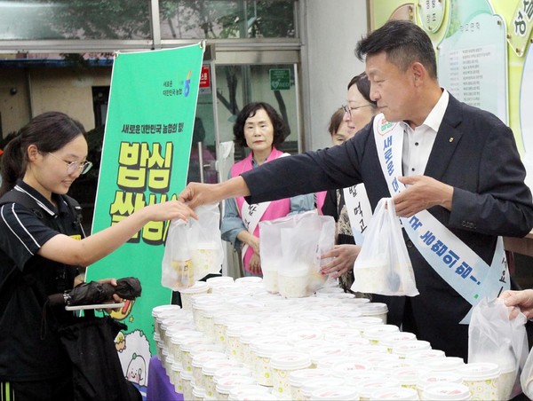김상수 농협서울본부장(오른쪽)이 동일중학교 학생에게 우리 쌀로 만든 아침밥을 나눠주고 있다.