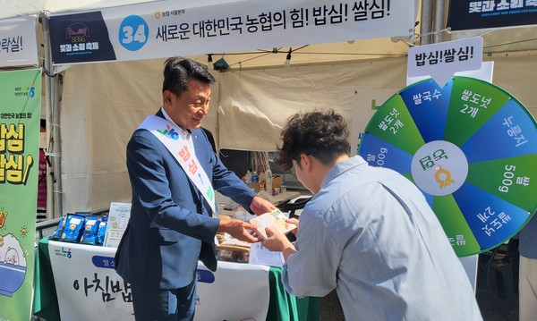 김상수 농협서울본부장(왼쪽)이 시민에게 아침밥 먹기 캠페인을 홍보하며 우리쌀 가공식품을 나눠주고 있다.