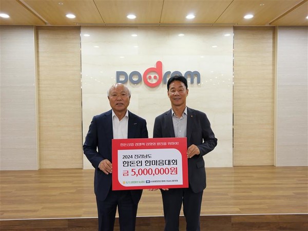박광욱 도드람양돈농협 조합장(왼쪽)이 ‘제7회 전라남도 한돈인 한마음대회’에서 오재곤 전남도협의회 회장(오른쪽)에게 후원금을 전달하고 있다.