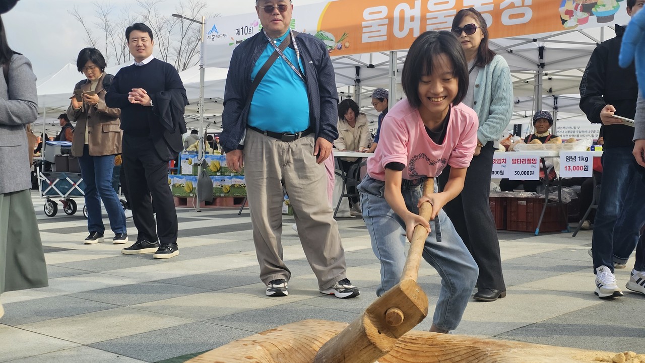 행사장을 찾은 어린이가 직접 떡메치기를 체험하고 있는 모습