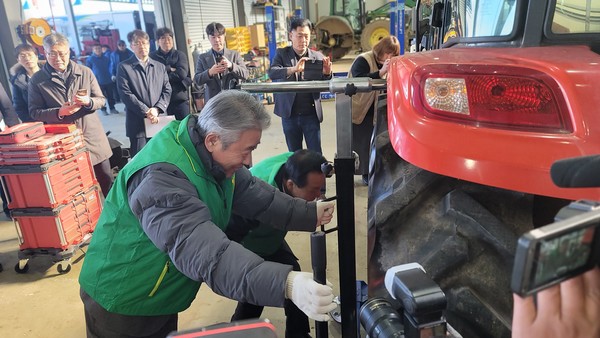강호동 회장이 트랙터 타이어를 교체하며 농기계 수리 시연을 하고 있다.