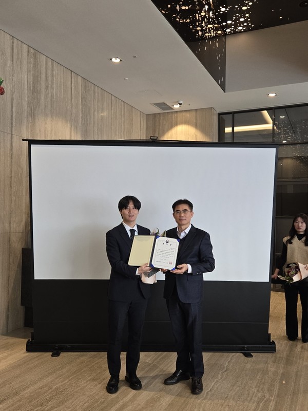 이수원 한강식품 대리(왼쪽)가 강운경 고용노동부 경기지청장(오른쪽)과 수상 기념 사진을 촬영하고 있다.