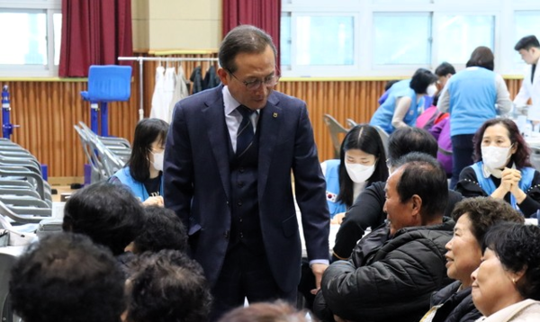 강호윤 조합장이 농촌 왕진버스 의료서비스에 참여한 지역주민들의 건강을 살피고 있다.