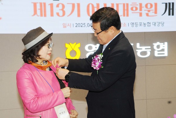 백호 조합장(오른쪽)이 수강생 대표에게 사회공헌실천재단 배지를 달아주고 있다.