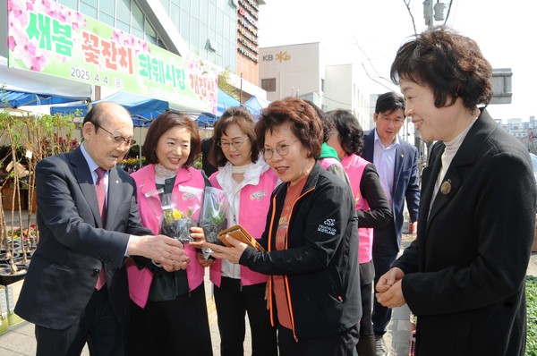 서울서남부농협은 4일 새봄맞이 화훼시장 개장식을 가졌다. 박준식 조합장(왼쪽 첫번째)이 화훼시장을 찾은 지역주민들에게 화훼모종을 나눠주고 있다.