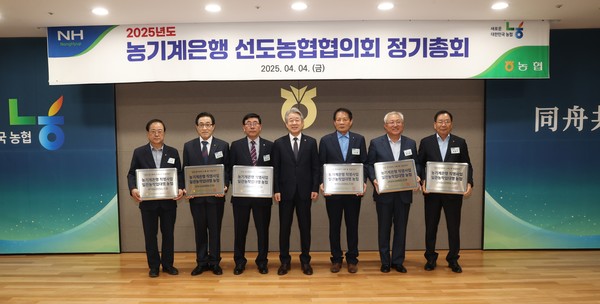 강호동 농협중앙회장(왼쪽 네번 째)이 농기계은행 선도농협협의회 정기총회에서 일관 농작업 대행 참여농협 조합장들에게 현판을 전달하고 기념촬영을 하고 있다