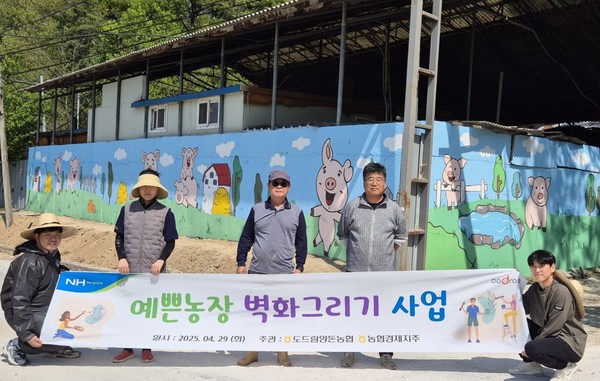 도드람양돈농협 조합원 아람농장 김춘일 대표(왼쪽에서 세번째)를 비롯한 임직원들이 ‘예쁜 농장 벽화 그리기’ 행사를 마친 후 기념사진을 촬영하고 있다.