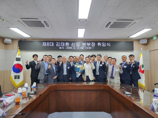 꽃다발을 든 신임 김태환 본부장과 김용상 전무 등 임직원들이 함께 기념사진을 찍고 있는 모습.