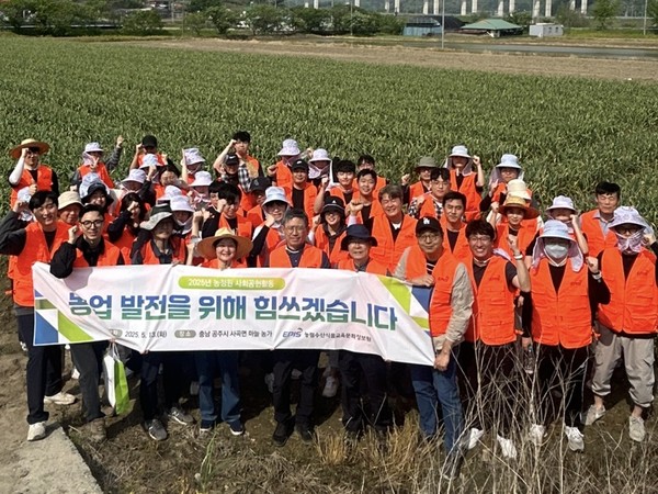 윤동진 농정원장(앞줄 가운데)를 비롯한 농정원 임직원들이 마늘밭에서 단체사진을 촬영하고 있다.