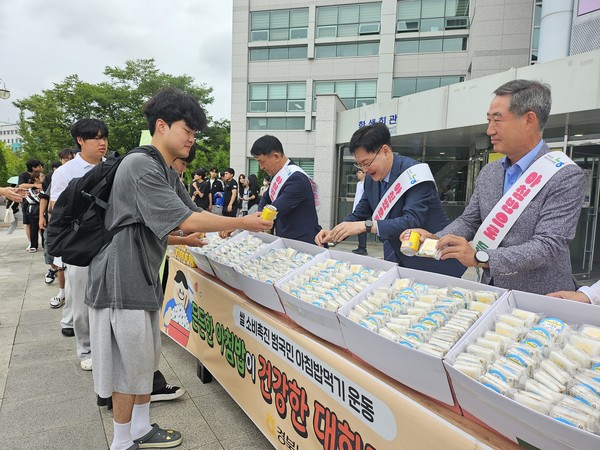 국립경국대학교 대학생들에게 백설기와 쌀 음료를 나눠주고 있다.