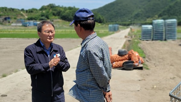 양파 수확이 한창인 현장에서 만난 농업인 조합원과 양파 수매 관련 이야기를 나누고 있는 강 조합장.