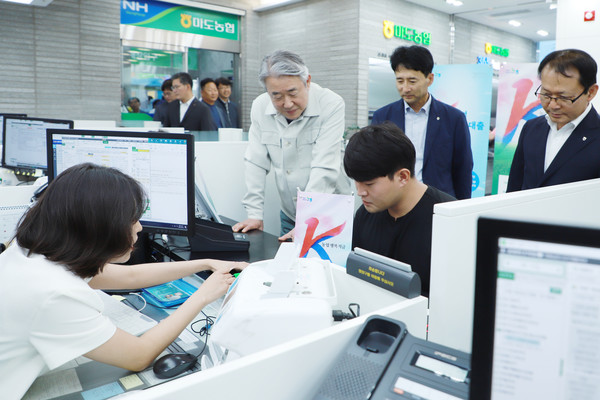  신상품 출시 행사에서 청년 농업인 고객이 K농업행복적금 가입 관련 안내를 받고 있다.