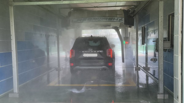브러쉬 없이 강력한 물줄기로 깔끔한 세차가 가능해 인기인 세차장 내부 모습.