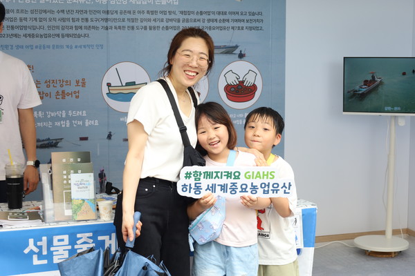 지난달 20일 하동 섬진강 일원에서 열린 하동섬진강문화 재첩축제2025에서 한 가족이 하동 GIAHS 홍보에 참여하고 있다.