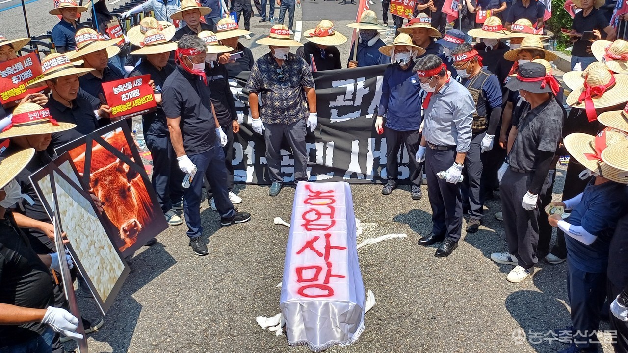 한우 소머리, 쌀, 사과를 담은 관에 붉은 글자로 '농업사망'을 적어뒀다.