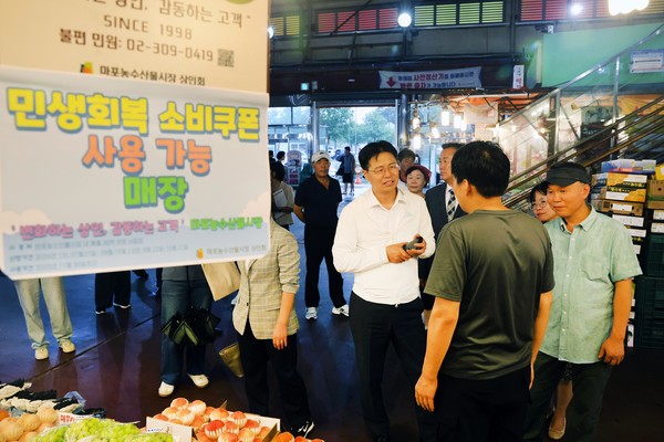 강형석 농식품부 차관(가운데)이 마포농수산물시장 상인과 소비쿠폰 사용 상황을 점검하고 있다.