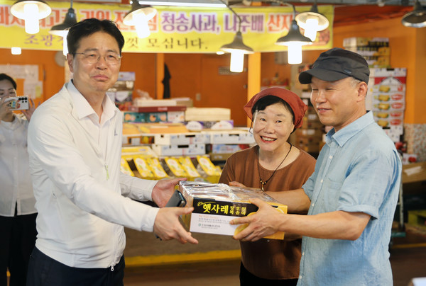 강형석 차관(왼쪽)이 소비쿠폰으로 복숭아를 구매하고 있다.