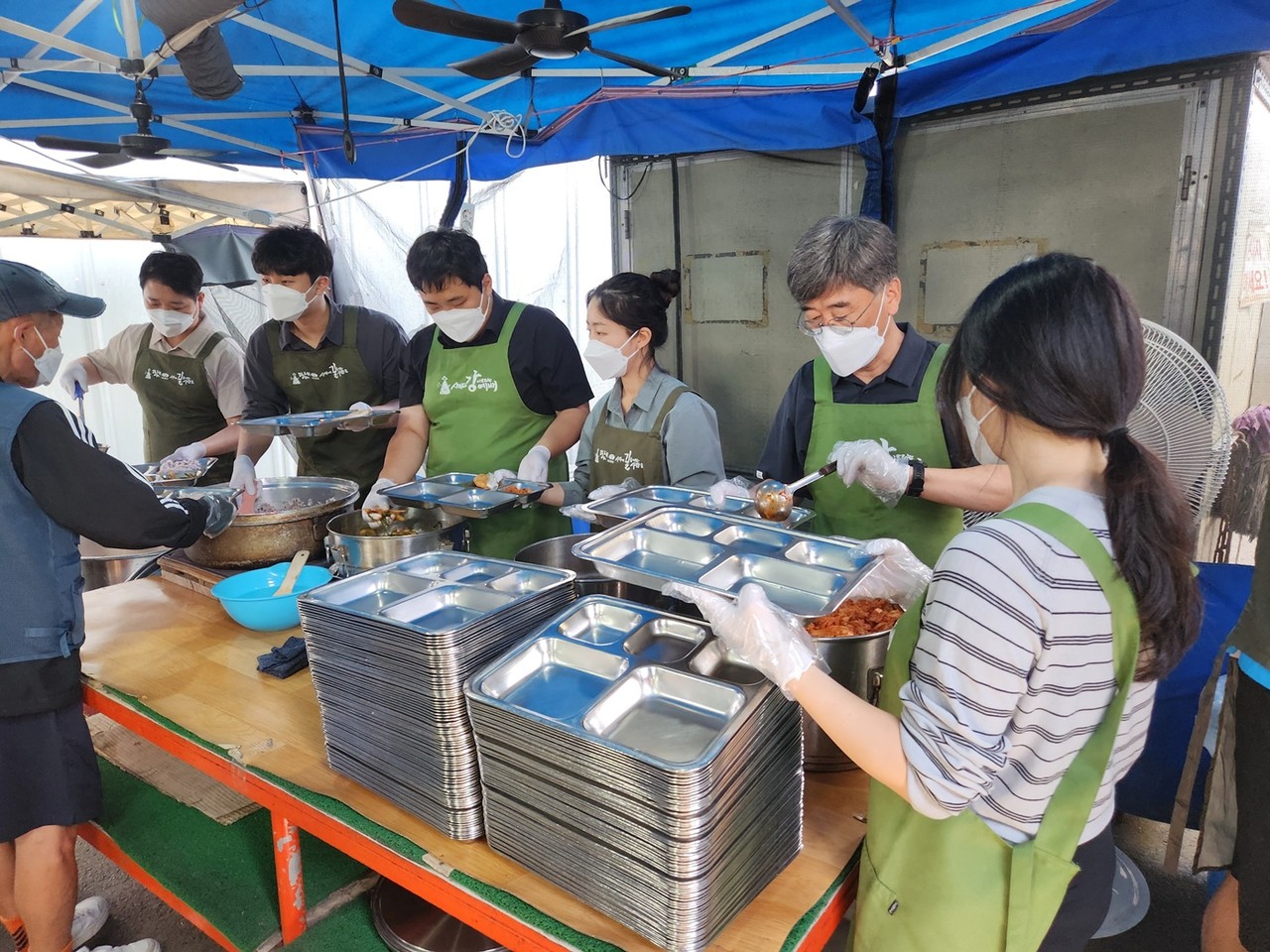서해동 농금원장(오른쪽 첫번째)와 서영규 노조위원장(왼쪽 첫번째)이 지역 취약계층에게 배식하는 모습.