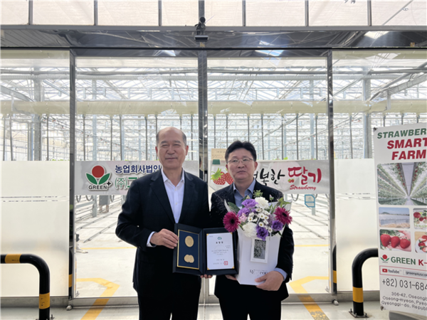 최창수 경기도농수산진흥원장(왼쪽)이 박정길 그린케이팜 대표에게 경기도 중소기업 유공 표창을 전달하고 있다.