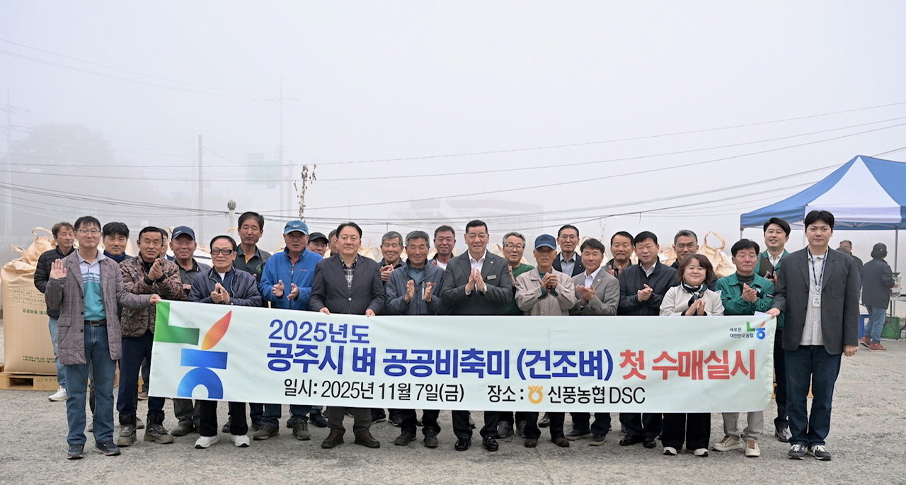 최원철 공주시장과 공주시농업정책과, 농업인, 농협관계자들이 첫 수매 현장을 기념하며 함께 사진을 찍고 있다.