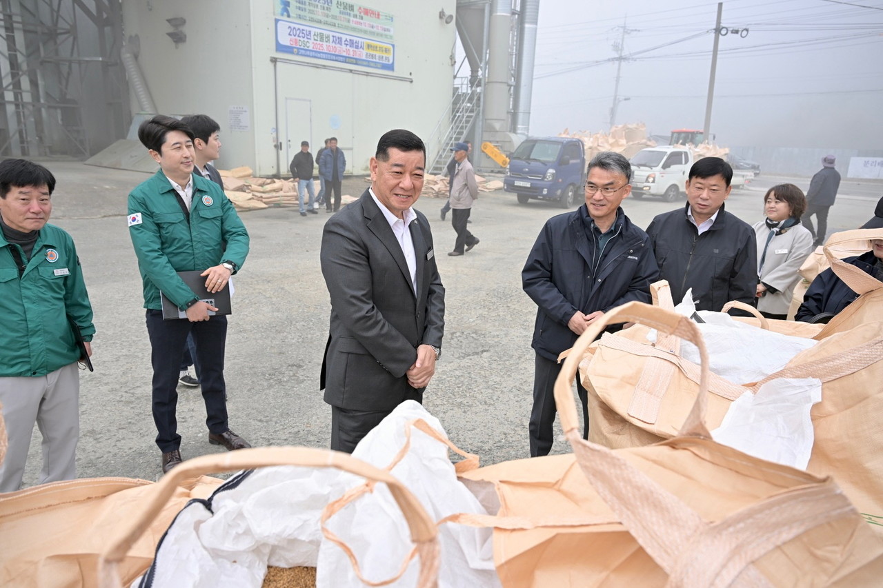 최원철 시장이 농업인들과 벼 상태와 보관 상황을 확인하며 대화를 나누고 있다.
