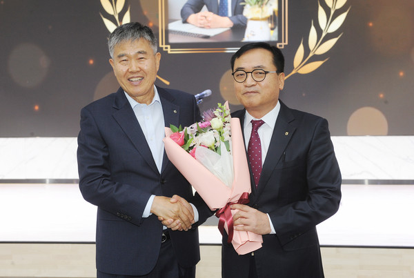 서용대 상임이사(오른쪽)가 진경만 조합장으로부터 꽃다발을 받고 기념촬영을 하고 있다.