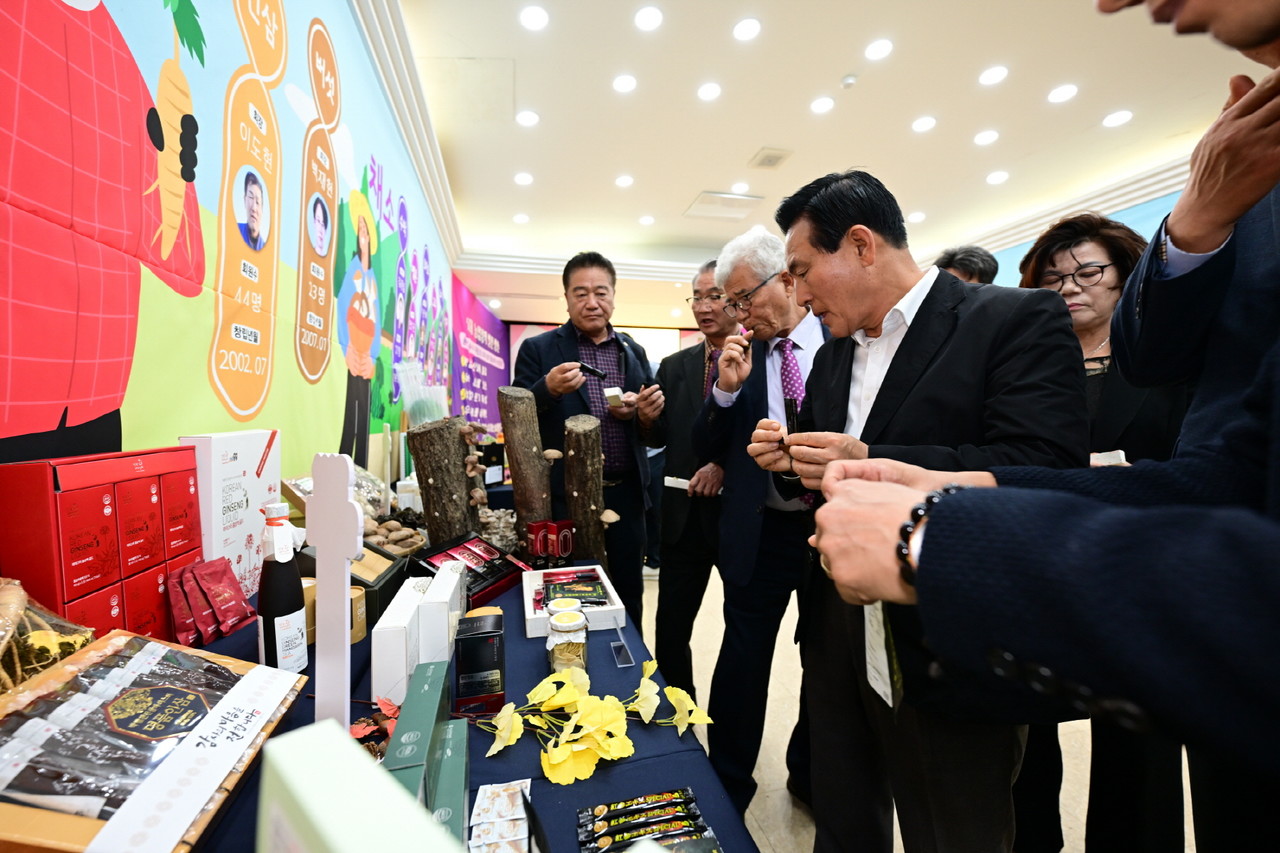 백성현 논산시장이 논산 농산물 가공식품 전시장을 둘러보고 시식하며 관계자들과 의견을 나누고 있다.