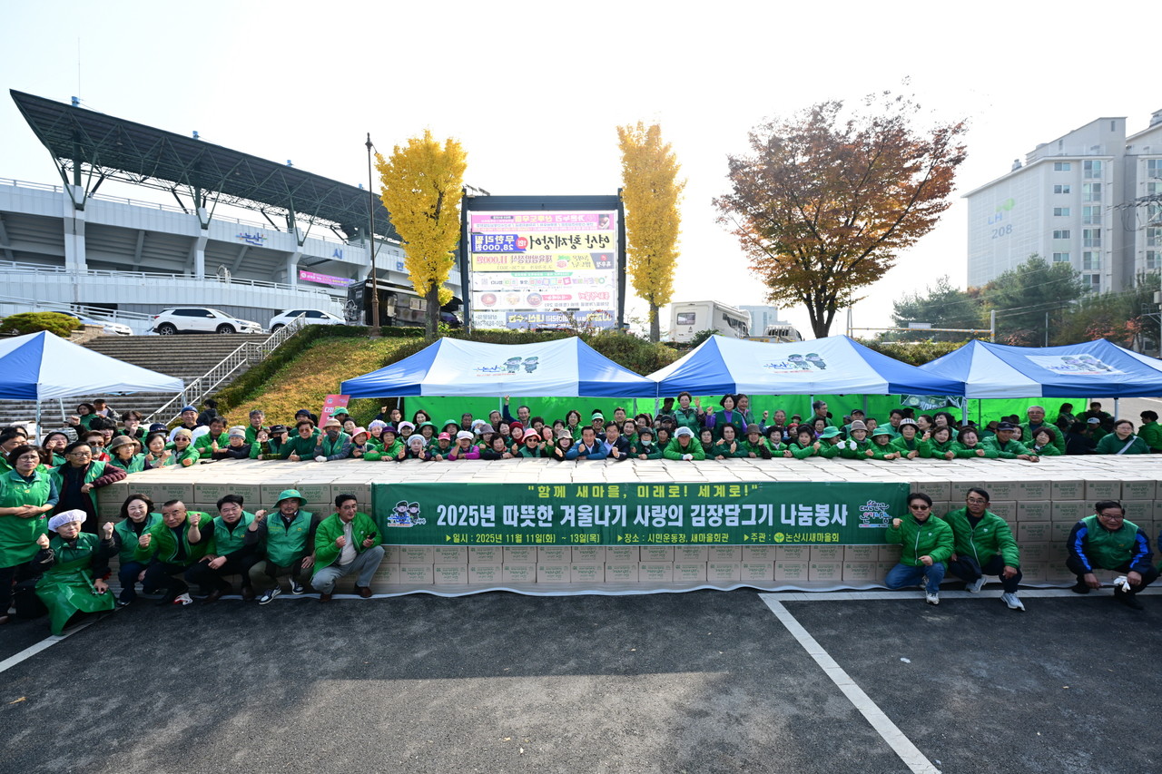 ‘사랑의 김장 담그기’ 행사에 참여한 논산시새마을회 회원들이 완성된 김치 상자 앞에서 단체 기념촬영을 하고 있다.