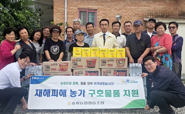 홍성표 조합장(앞줄 왼쪽에서 다섯번째)과 임직원들이 집중호우로 피해를 입은 안성 조합원 농가를 방문해 구호물품을 전달하고 있다.