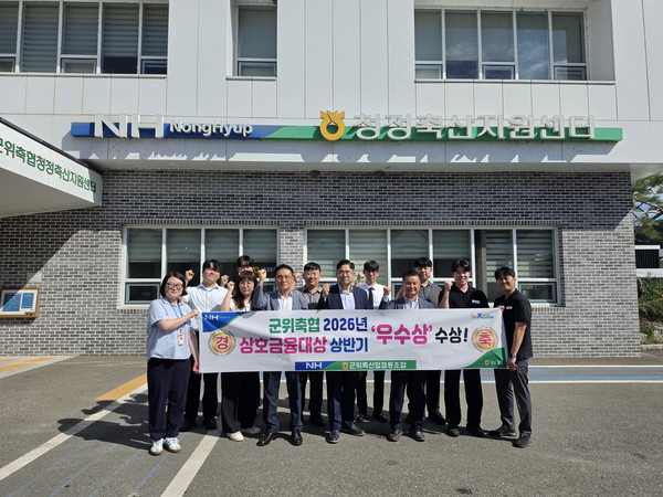 군위축협이 2026 상호금융대상 상반기 우수상을 수상하는 영예를 안았다. 사진은 수상 후 박배은 조합장(가운데)과 백승원 상임이사(가운데 왼쪽)를 비롯한 임직원들이 단체 기념촬영을 하고 있다.