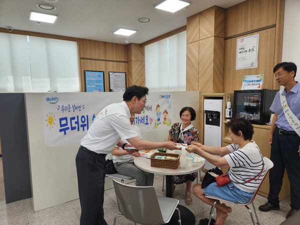 김진욱 NH농협은행 경북본부장이 농협 칠곡군지부 무더위 쉼터을 방문해 현장점검과 함께 이용객에게 농산물 음료를 나눠주고 있다.